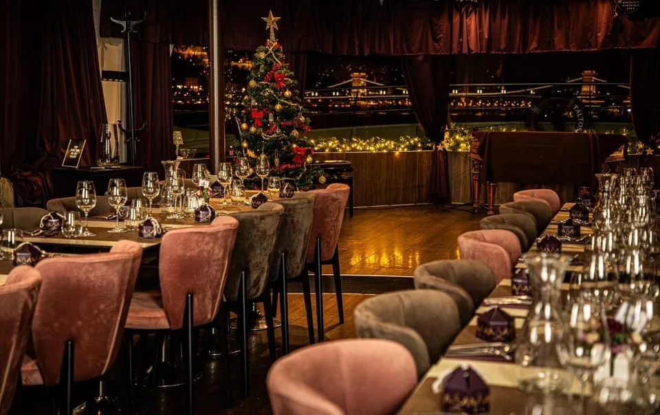 A table set for Christmas dinner by the window of a Danube cruise boat in Budapest at Christmas