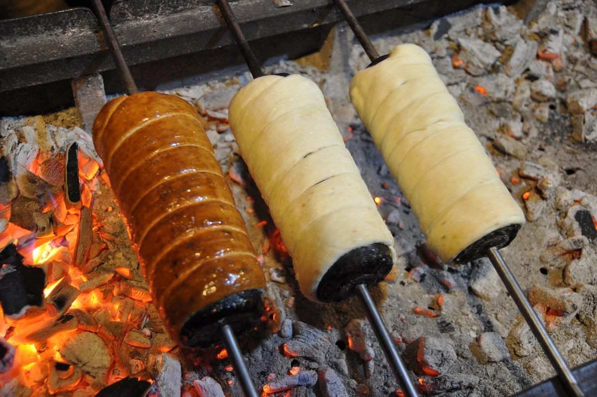 Chimney cakes turning on spits over glowing coals, the treat included on a Budapest Christmas market tour