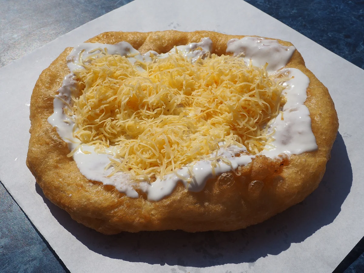 Lángos with sour cream and cheese, a market snack to buy on a Budapest Christmas markets tour